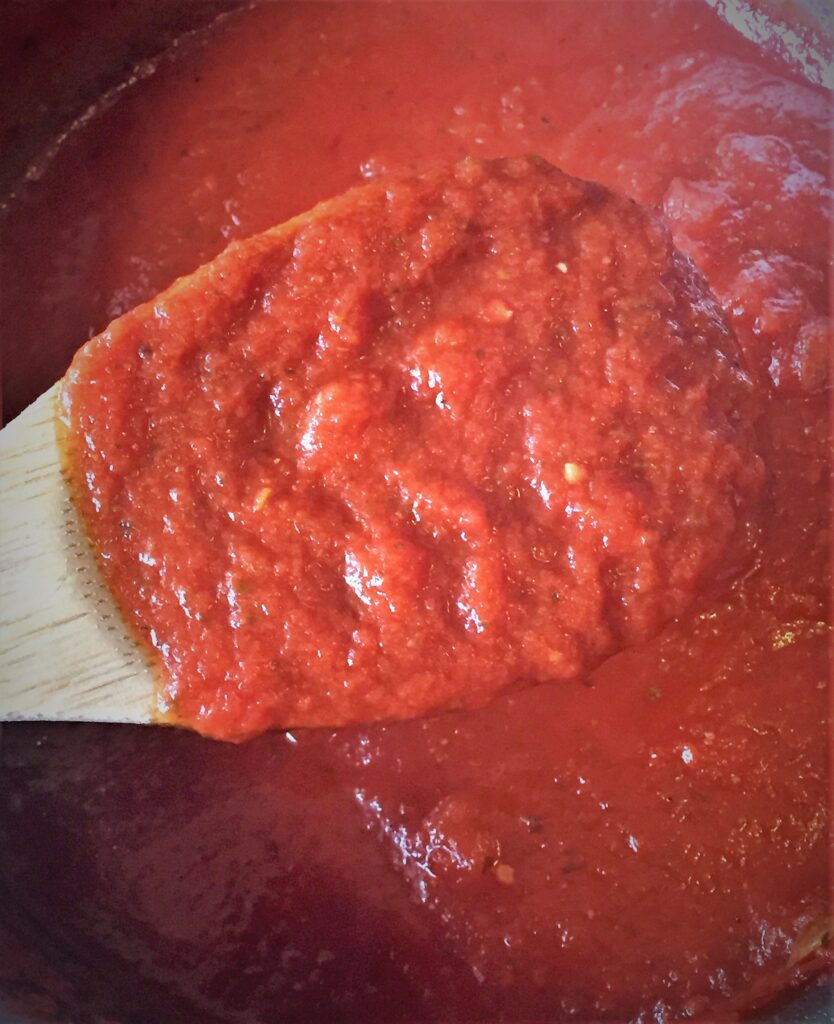 Homemade marinara sauce on wooden spoon