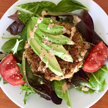 Salad topped with Chickpea Veggie Patty, drizzled with Chipotle Lime Sauce.