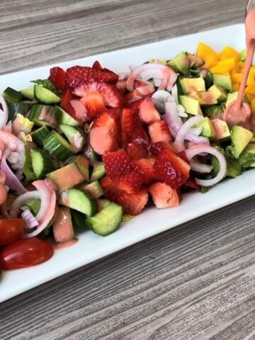 Strawberry Mango Romaine Salad with Raspberry Vinaigrette dressing pour courtesy of That Green Lyfe